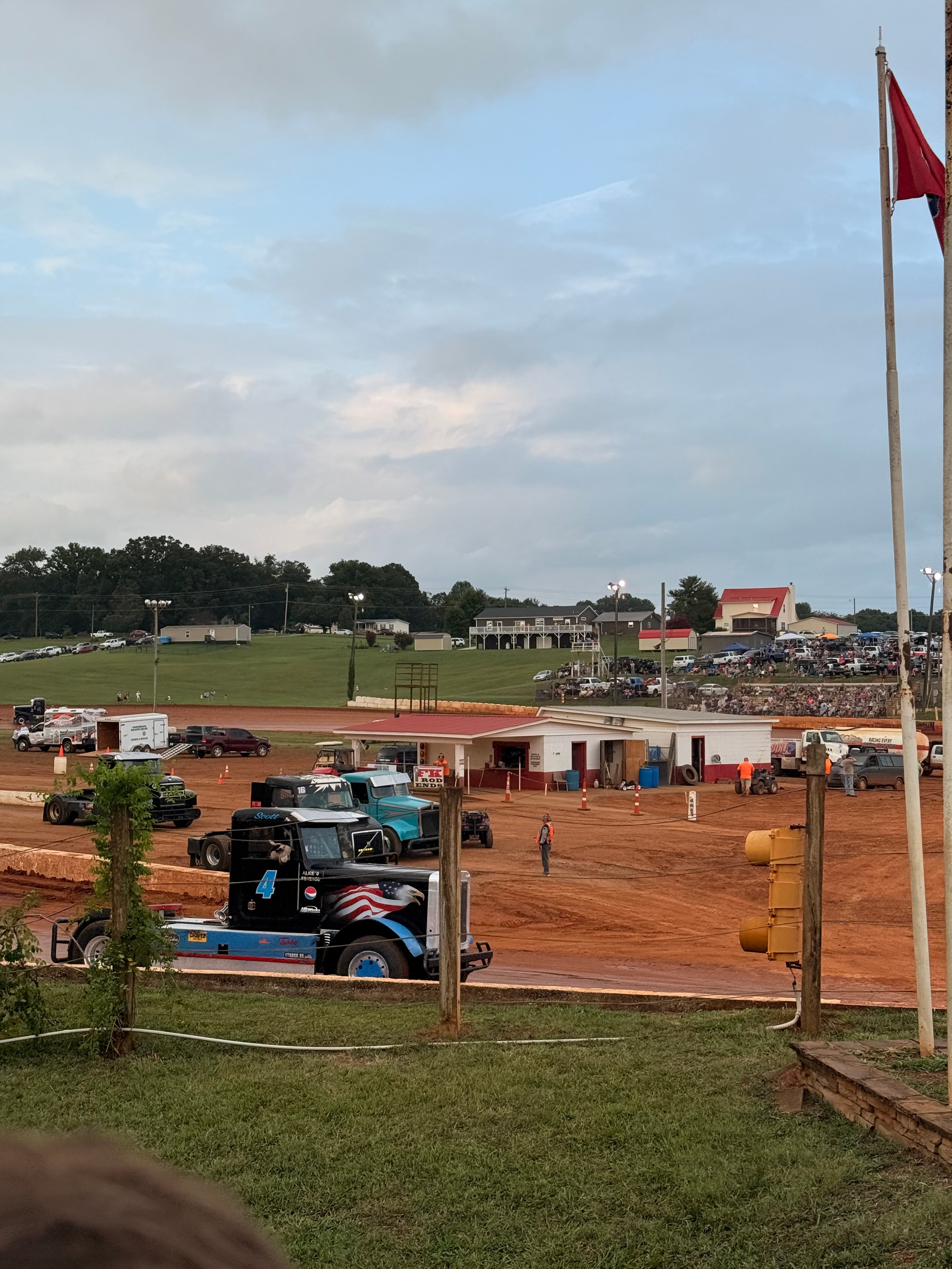 Dirt track event with trucks and crowd at a local fairground