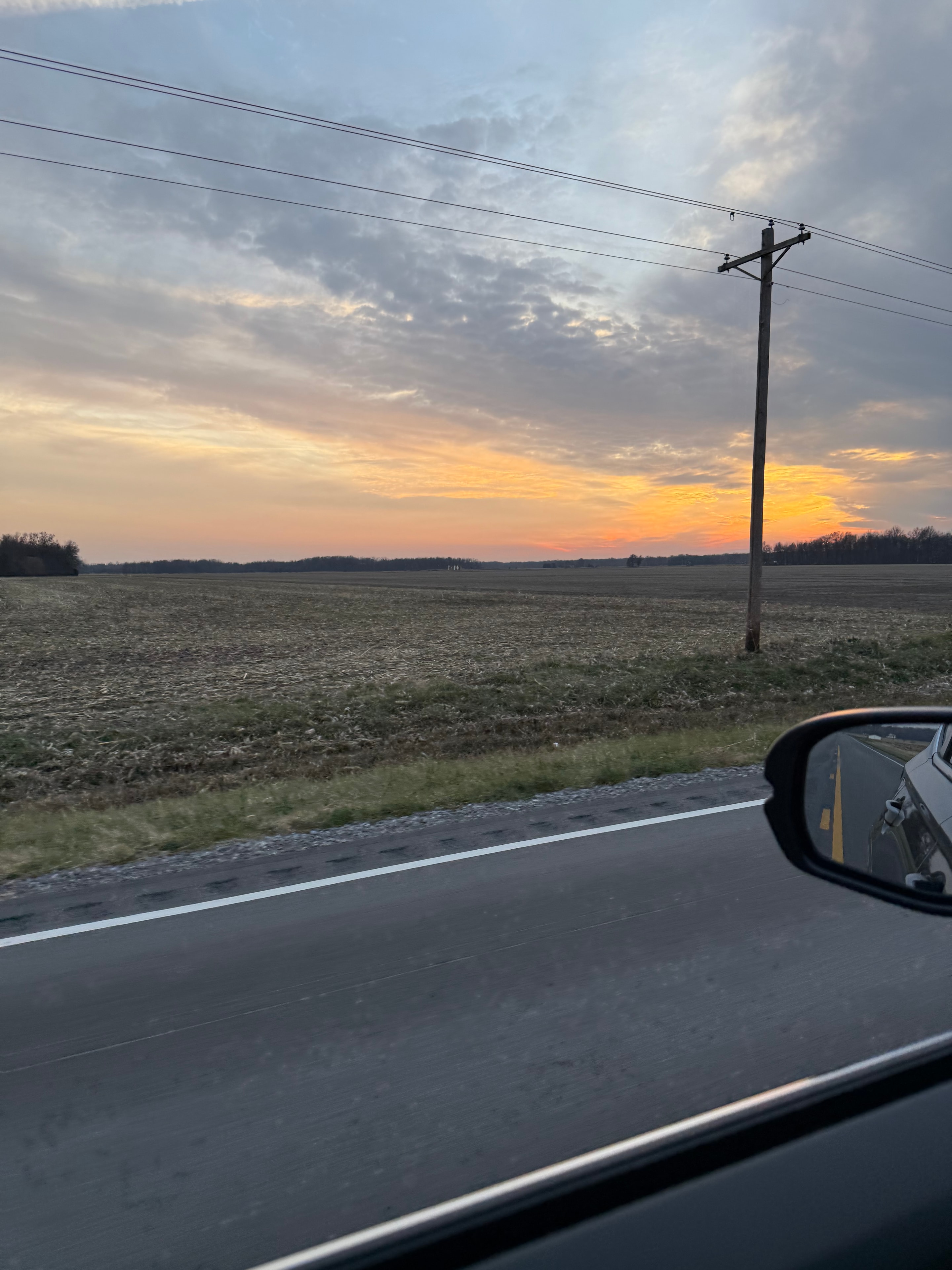 Fiery sunset over a rural highway with power lines