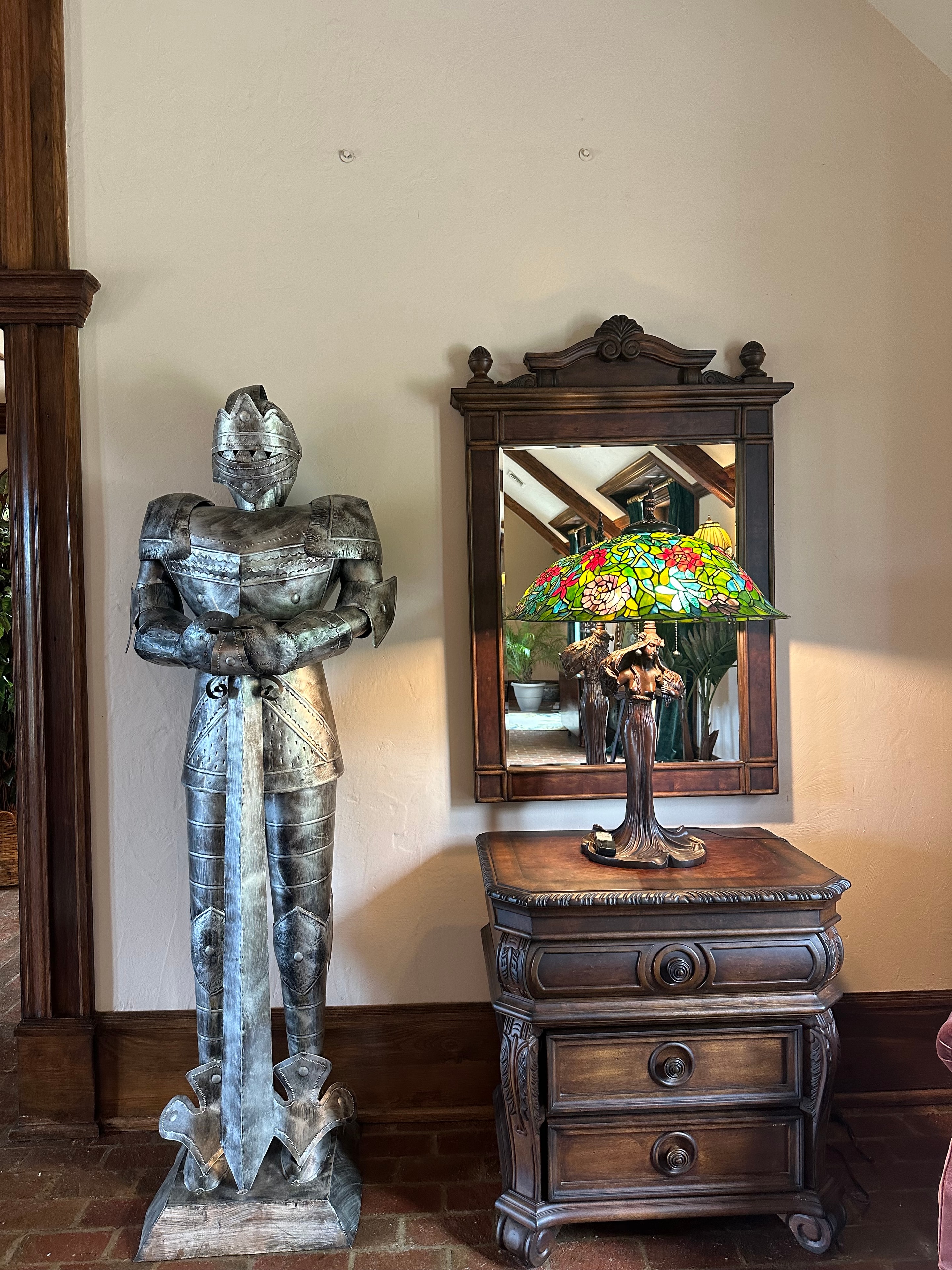 Decorative knight statue with Tiffany lamp and ornate wooden furniture
